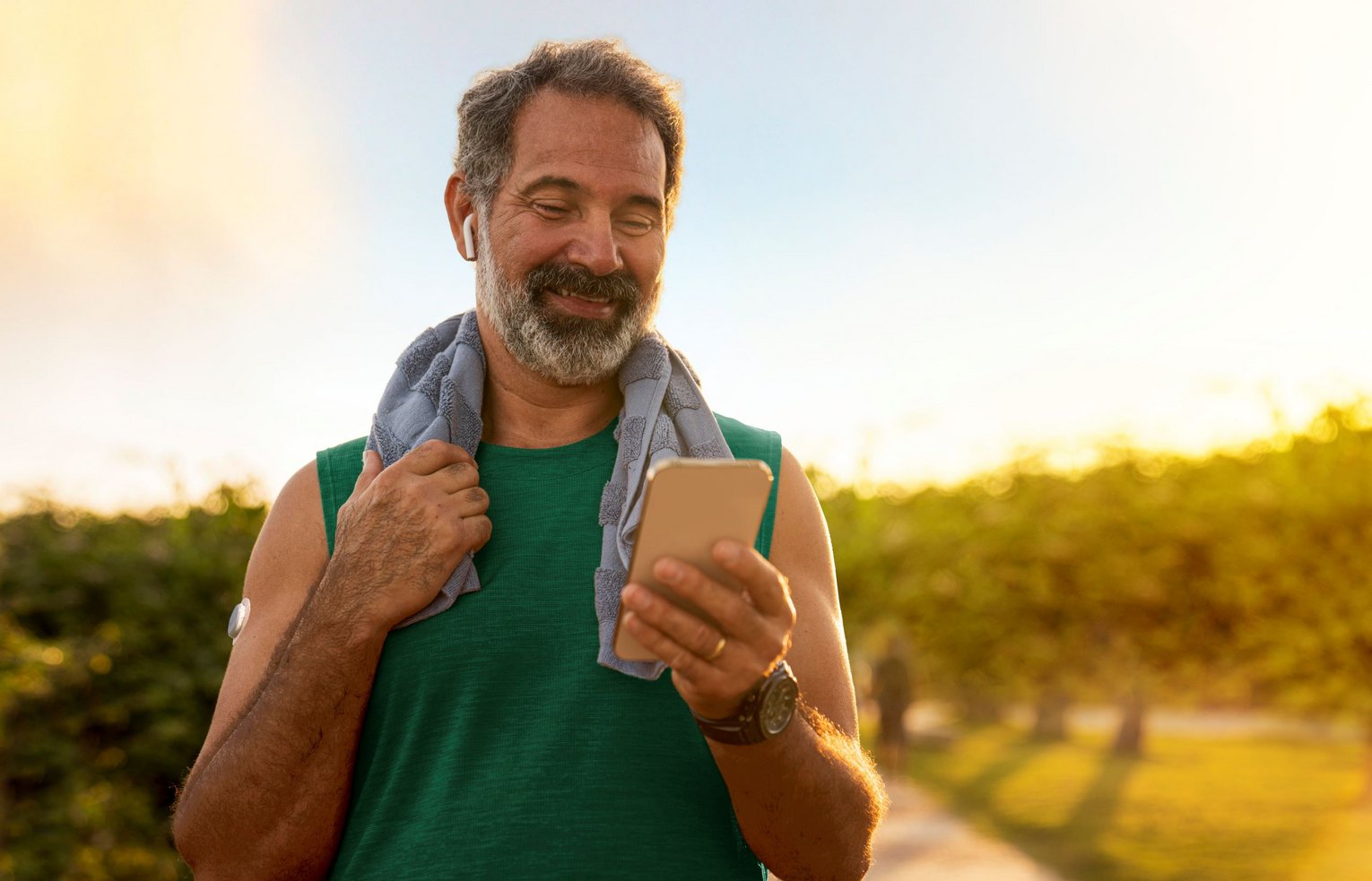 Diabetes Schwerpunktpraxis Appsteuerung Mann überprüft beim Sport seinen Zuckerwert per App