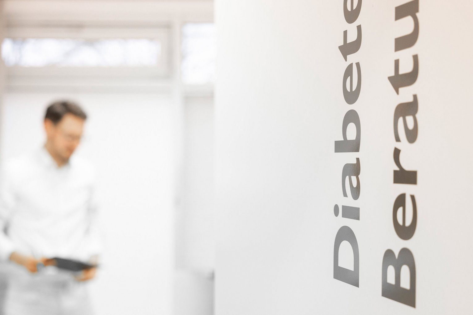 Schild Diabetespraxis Aufdruck Diabetes Beratung im Hintergrund ein Arzt 