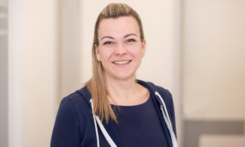 Freundlich lächelnde Frau steht vor Kamera